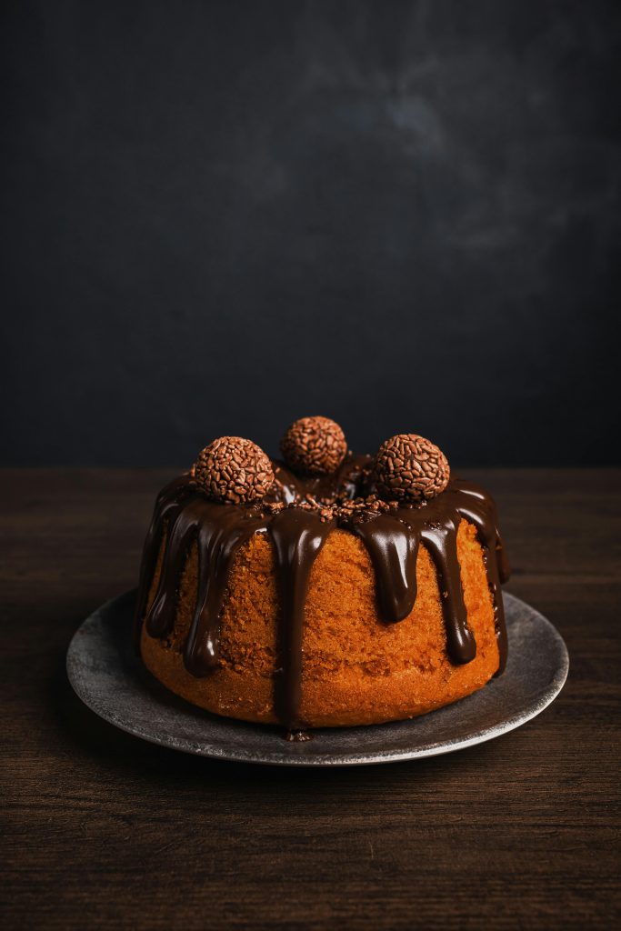 Katta Coffee and Kitchen Delicious chocolate drizzled cake topped with brigadeiros, perfect for dessert lovers.